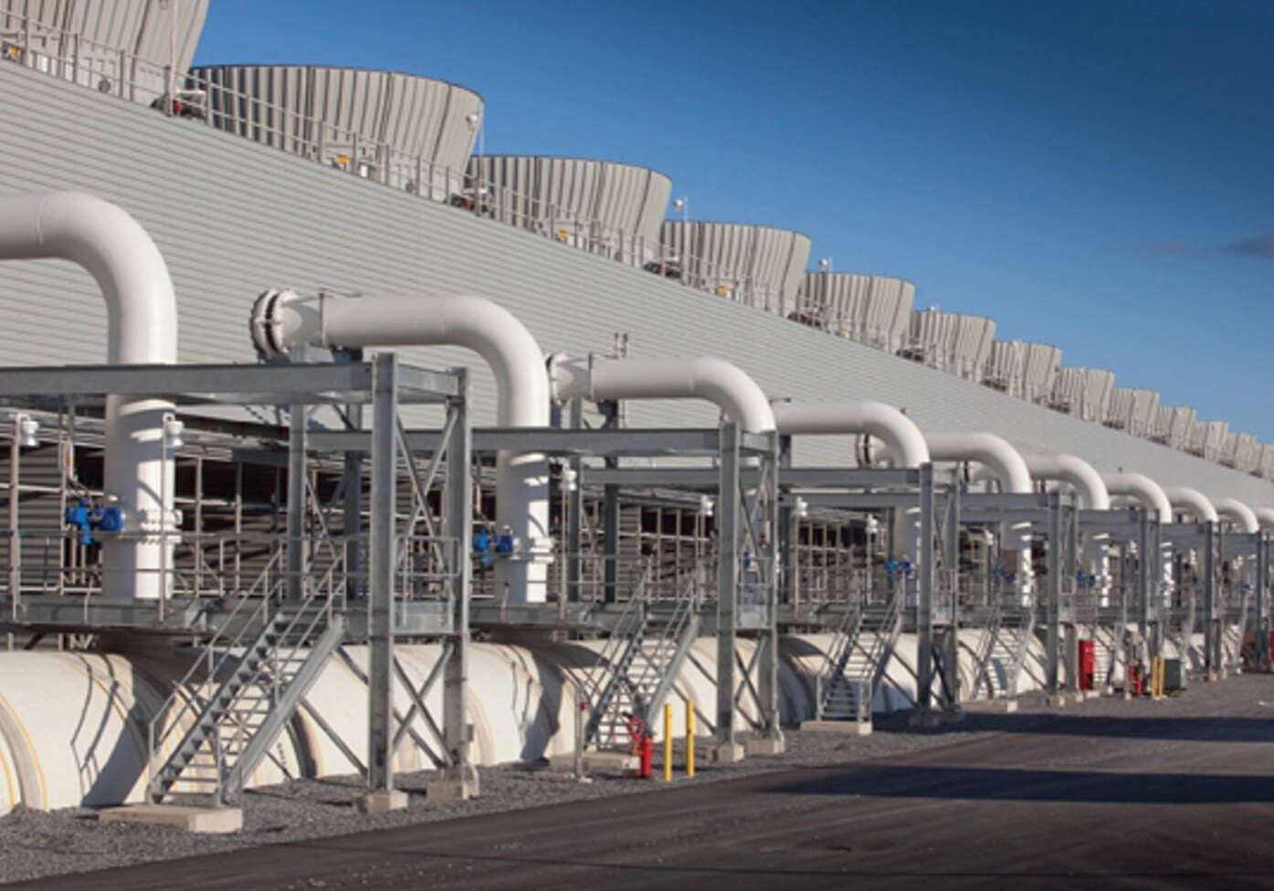 A large industrial building with pipes on the side.